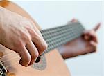 Musician playing acoustic guitar, close-up