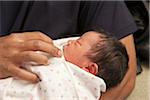 Close-up of father holding newborn baby girl, USA