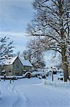 Traditional cottage during snowy weather in the village of Swinbrook, The Cotwolds