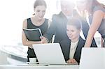 Business people discussing over laptop in office cafeteria