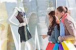 Young female friends window shopping