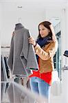 Young woman selecting sweater in store