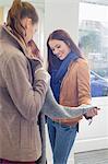 Female friends choosing sweater in store