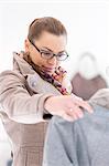 Young woman analyzing sweater in store