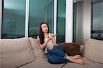 Full length of young woman watching TV in living room