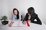 Happy businesswomen working at desk in office