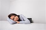 Tired businesswoman leaning at office desk