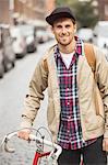 Man pushing bicycle on city street