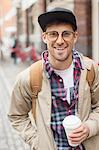 Man with cup of coffee on city street