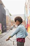 Woman pushing bicycle on city street