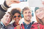 Friends taking self-portraits with camera phones outdoors