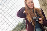 Woman holding camera outdoors