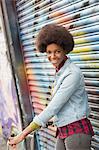 Woman with bicycle in front of graffiti wall