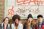 Friends smiling together in front of graffiti window