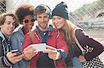 Friends taking self-portrait with camera phone outdoors