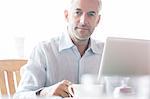 Businessman using laptop in cafe