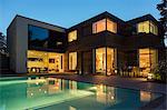 Modern house and swimming pool illuminated at dusk