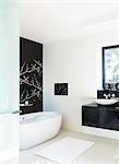 Wall art and soaking tub in modern bathroom