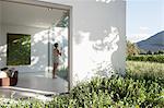 Woman standing at window in modern house