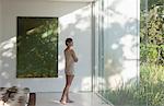 Woman standing at window in modern bedroom