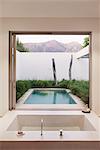 Modern bathroom overlooking swimming pool and mountains