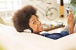 Woman listening to headphones on sofa
