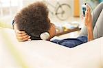 Woman listening to headphones on sofa