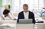 Man using laptop at desk in living room