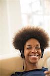 Woman listening to headphones on sofa