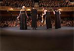 Quartet bowing on stage in theater