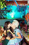 Women kissing at party