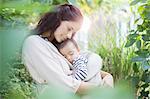 Mother holding baby girl outdoors