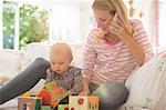 Mother with baby girl talking on cell phone