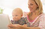 Mother and baby girl using digital tablet