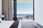 Modern bedroom and balcony overlooking ocean