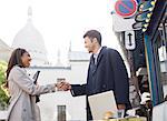 Business people shaking hands on city street