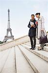 Business people talking on steps near Eiffel Tower, Paris, France