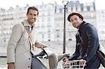 Businessmen on bicycles along Seine River, Paris, France