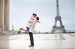 Couple hugging near Eiffel Tower, Paris, France