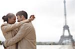 Couple hugging near Eiffel Tower, Paris, France