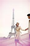 Couple descending stairs by Eiffel Tower, Paris, France