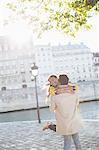 Couple hugging along Seine River, Paris, France