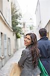 Couple carrying shopping bags in street near Sacre Coeur Basilica, Paris, France