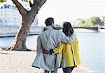 Couple walking along Seine River, Paris, France