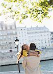 Couple hugging along Seine River, Paris, France