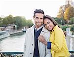 Couple hugging on Pont des Arts bridge over Seine River, Paris, France