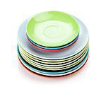 Colorful plates and saucers over wooden table background. View from above