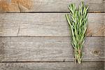 Rosemary bunch on wooden table background with copy space