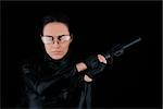 Woman in a black leather suit holding a gun