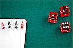 poker card and dice in corner in of a green fabric background